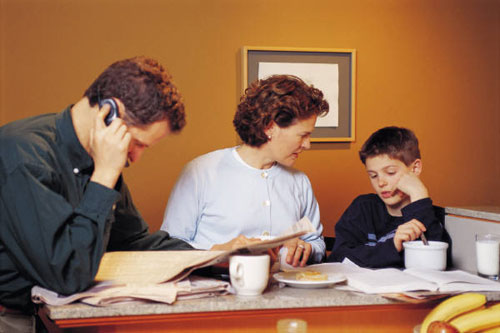 Image of two parents helping a child with homework